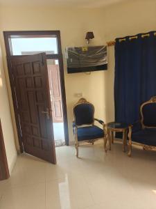 a room with two chairs and a table and a door at Paris pines Muree Bhurban in Bhurban