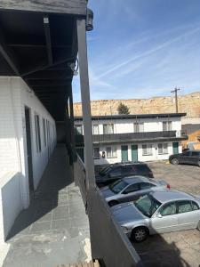 zwei Autos auf einem Parkplatz neben einem Gebäude geparkt in der Unterkunft The Mint Motel in Rock Springs