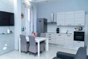 a kitchen with a table and chairs and a kitchen with white cabinets at PORTACAPUANA Guest House in Naples