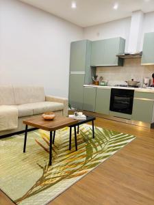 a living room with a coffee table and a kitchen at AB apartment Pistoia in Pistoia