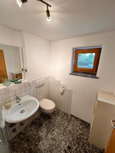 a bathroom with a sink and a toilet and a window at Monteur und Ferienwohnung nahe Ulm Zentrum, Legoland Deutschland 