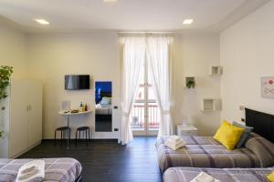a room with two beds and a living room at Calaba SpaccaNapoli in Naples