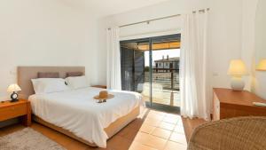 a bedroom with a bed and a large window at Marina Park 1721 in Albardeira +11 photos