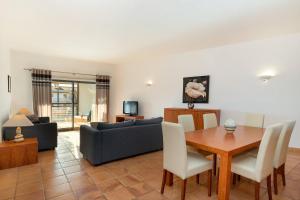a living room with a table and a couch at Marina Park 1721 in Albardeira