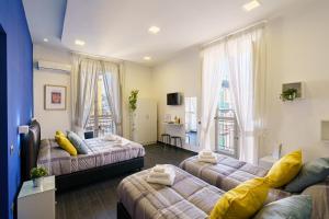 a living room with two beds and two windows at Calaba SpaccaNapoli in Naples +66 photos