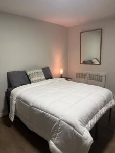 Schlafzimmer mit einem großen weißen Bett und einem Spiegel in der Unterkunft The Mint Motel in Rock Springs