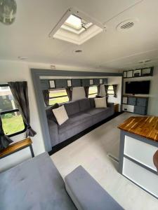 Una sala de estar en una casa rodante con un sofá. en Clamping Caravan, en Whanganui