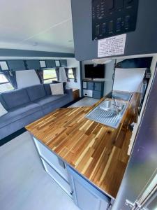 Una cocina y sala de estar con encimera de madera. en Clamping Caravan, en Whanganui