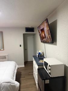 ein Schlafzimmer mit einem Bett und einer Mikrowelle auf einem Schreibtisch in der Unterkunft The Mint Motel in Rock Springs