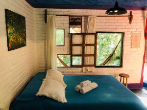 a bedroom with a blue bed with towels on it at Pousada Estância Rio Acima in Itamonte