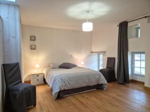 une chambre avec un lit et deux chaises dans l'établissement La Charmésienne, à Charmé