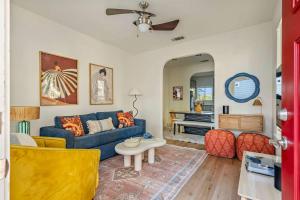 een woonkamer met een blauwe bank en een tafel bij The Backyard Collective 6BR 2 Homes Pool & More in Austin