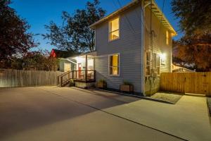 een wit huis met een hek en een oprit bij The Backyard Collective 6BR 2 Homes Pool & More in Austin +57 foto's