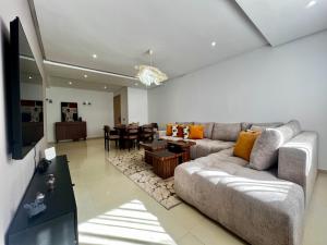 Urban Chic 2BR - Prestigia near stadium في الرباط: غرفة معيشة مع أريكة وغرفة طعام