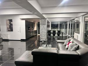 a living room with a couch and some chairs at Sky17 Penthouse Sibiu in Şelimbăr