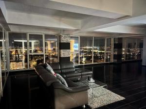 a living room with a couch and a city skyline at Sky17 Penthouse Sibiu in Şelimbăr