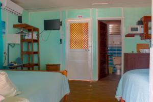 a room with a bedroom with a bed and a door at Julia's Beachfront Guesthouse and Cabanas in Placencia Village