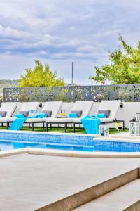 Villa Palace Al Nera في تروغير: صف من كراسي الصالة بجانب المسبح