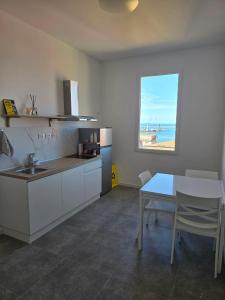 een keuken met een wastafel, een tafel en een raam bij DANITO Rooms 7 in Ancona
