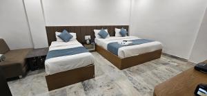 a hotel room with two beds in a room at HOTEL MAHER Inn in Ahmedabad