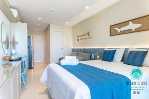 Refúgio Verão - Flat de alto padrão na praia do Cupe - Porto de Galinhas في بورتو دي غالينهاس: غرفة نوم بسرير كبير وملاءات زرقاء وبيضاء