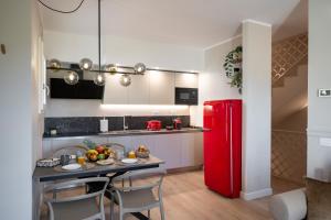 Una cocina con una mesa y un refrigerador rojo. en NEW Casa Florentia, en Ambrogiana 14 fotos más