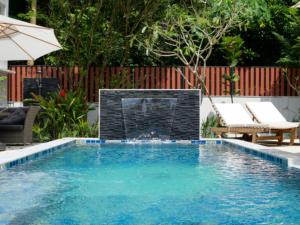 a swimming pool with a fire place in a backyard at Baan Ati Villas in Ban Han Pa To