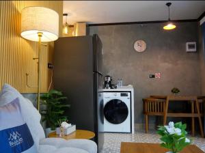 ein Wohnzimmer mit einem Kühlschrank und einem Tisch in der Unterkunft Baan Ati Villas in Ban Han Pa To