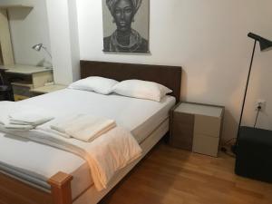 a bedroom with a bed with a black and white picture on the wall at First Choice Apartment in Skopje