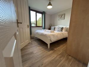 ein Schlafzimmer mit einem Bett und einem Fenster in der Unterkunft Athelington Lodge - Oak in Horham