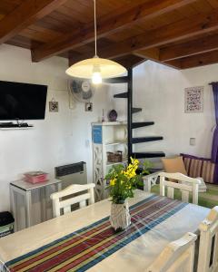 a dining room with a table with a vase on it at Cabaña Paz in Capilla del Monte