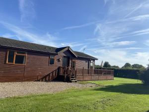 Field View 2 bed-No pets-Hornbeam في Horham: كوخ خشبي محاط بسياج خشبي بجوار فناء +7 صور