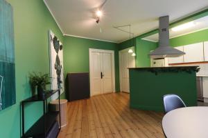 a living room with green walls and a table and chairs at Danmarksgade XXL-Suites in Aalborg +16 photos