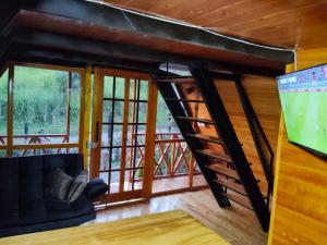 a living room with a spiral staircase in a cabin at Cabaña El Resguardo in La Capilla