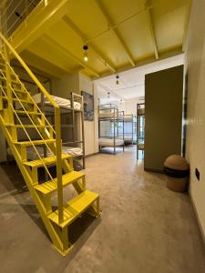 a room with bunk beds and a yellow staircase at Testudo Madiha in Matara