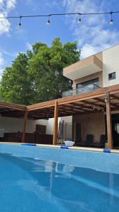 a house with a swimming pool in front of a house at Casa de alto padrão com piscina,quadra e jacuzzi em condomínio in Guarapari