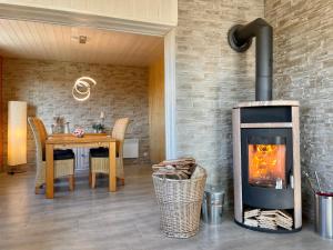 a fireplace in a living room with a table and a dining area at Panoramablick in Hainfeld