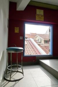 a stool in a room with a large window at Betel Box Backpackers Hostel in Singapore