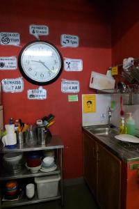 a kitchen with a clock hanging on a wall at Betel Box Backpackers Hostel in Singapore