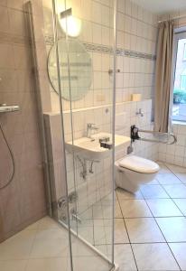 a bathroom with a shower and a sink and a toilet at Ferienwohnung Residenz am Sandstrand Norddeich in Norden +21 photos
