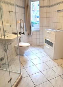 a bathroom with a toilet and a sink at Ferienwohnung Residenz am Sandstrand Norddeich in Norden
