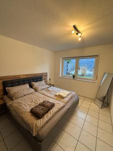a bedroom with a large bed with a window at Moselzeit - Moderne Ferienwohnung mit Terrasse und Burgblick in Bernkastel-Kues +3 photos