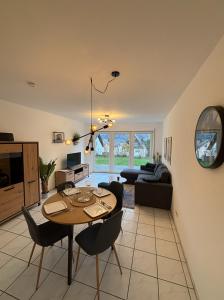 a living room with a table and chairs at Moselzeit - Moderne Ferienwohnung mit Terrasse und Burgblick in Bernkastel-Kues