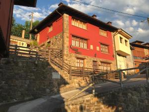 un edificio rojo con escaleras delante en La Portiella, en Bueres