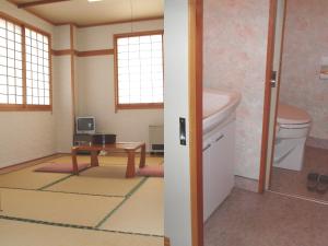 a bathroom with a sink and a toilet and a table at Shinazawa in Nozawa Onsen
