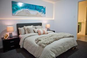 een slaapkamer met een groot bed en twee lampen bij Entire home in Cranbourne West in Cranbourne