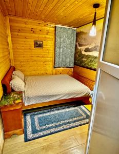 een kleine kamer met een bed in een hut bij Casa Beijing in Braşov