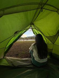 een vrouw in een groene tent bij NaboCamp in Linares