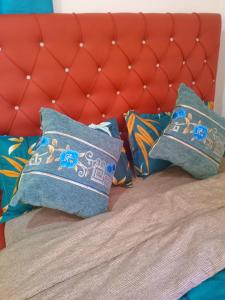 una cama con dos almohadas azules y un cabecero rojo en Master Home, en Baatsona