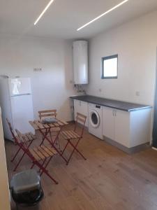 eine Küche mit Stühlen und einem Tisch und einem Kühlschrank in der Unterkunft House with jacuzzi in Atei - 70 m² in Atei